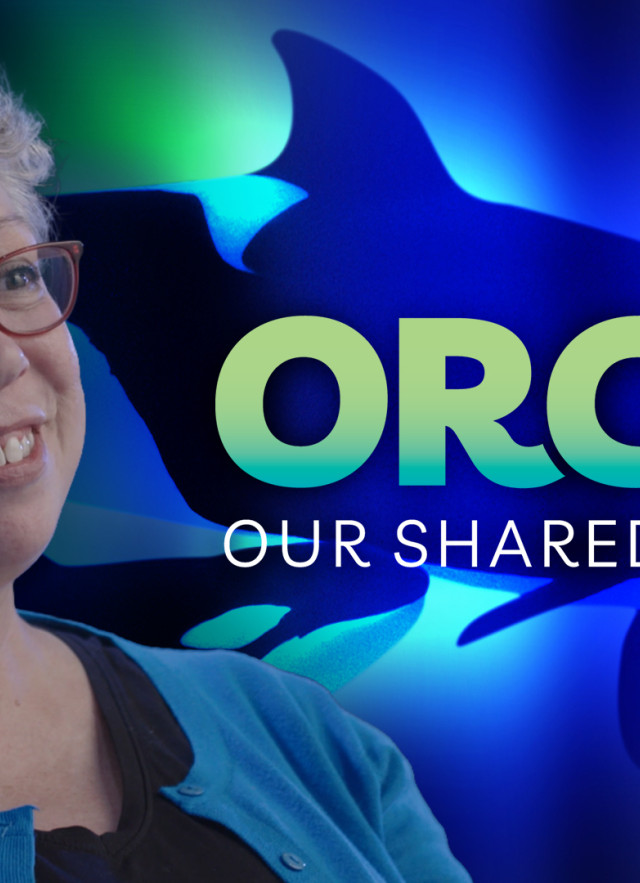 Amanda Killian in front of an orcas with green, blue, and purple lighting