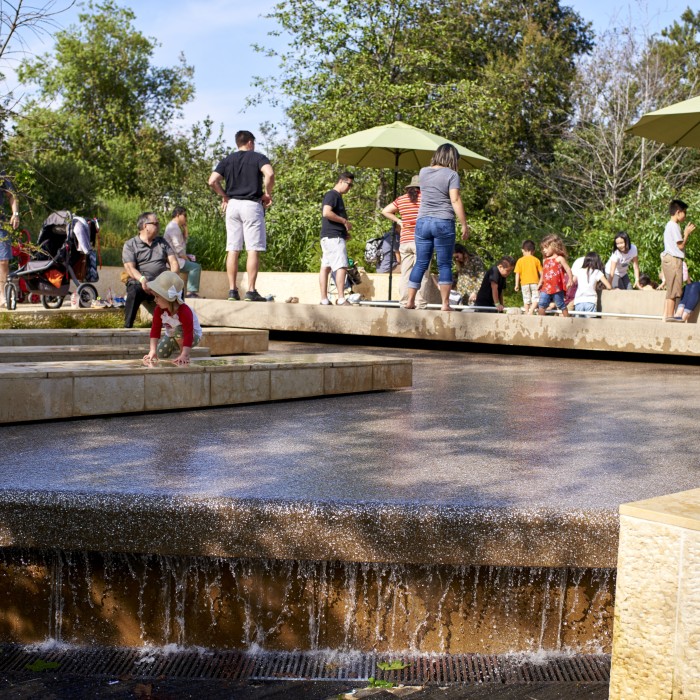 people in urban waterfall in nature gardens 