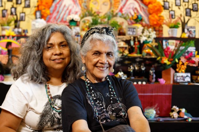 Ofrenda artists pictured in front of altar 