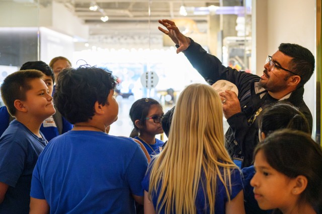 Miguel interpreting with a mountain lion track print at the P-22 exhibit.