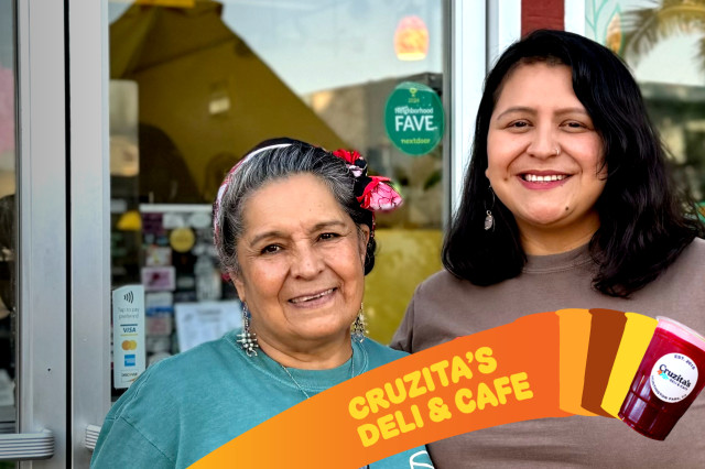 Two women stand together and smile warmly in front of the glass entrance of Cruzita's Deli. A vibrant orange graphic at the bottom includes the business name and a cup of their signature deep red strawberry jamaica.