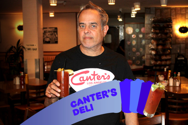 man holding cup wearing black t shirt with white and red graphics. 
