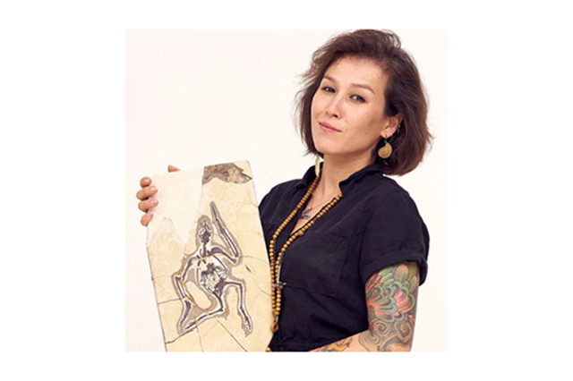 Head and shoulders portrait of Dr. Jingmai O’Connor holding a fossil
