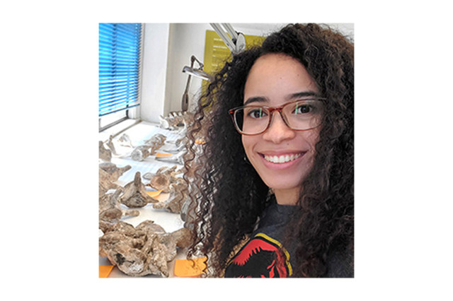 Head and shoulders portrait of Kiersten Formoso with fossils on a table 