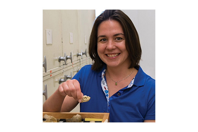 Head and shoulders portrait of Dr. Rachel Racicot holding a fossil