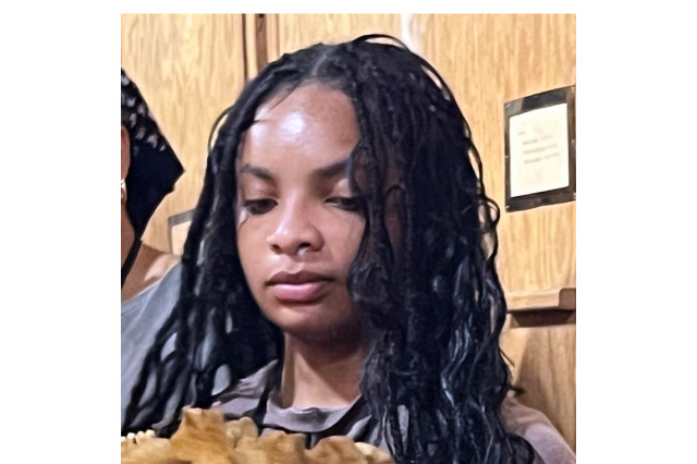 Shariah Kyle holding and looking down at a specimen