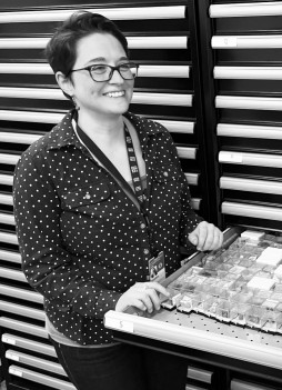 Kriss in front of an open drawer of micromounts from the collection in the Mineral Sciences laboratory.