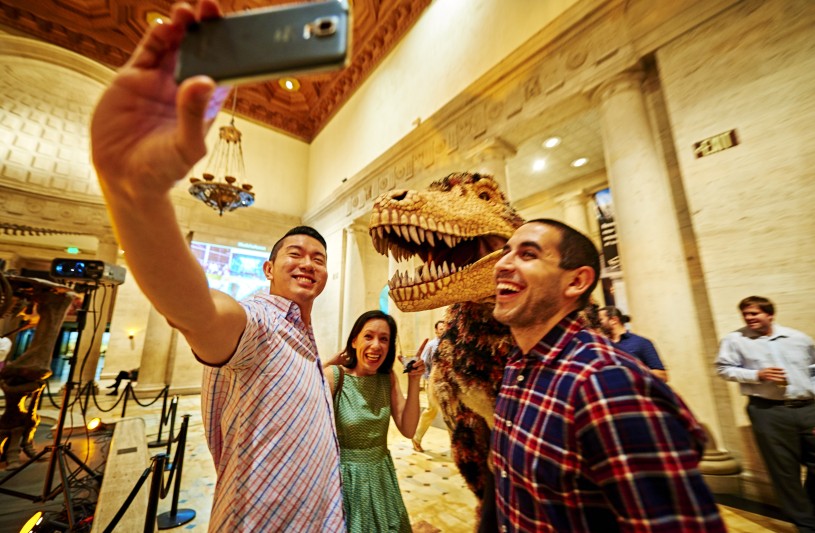 guests taking selfie with dinosaur encounters puppet grand foyer