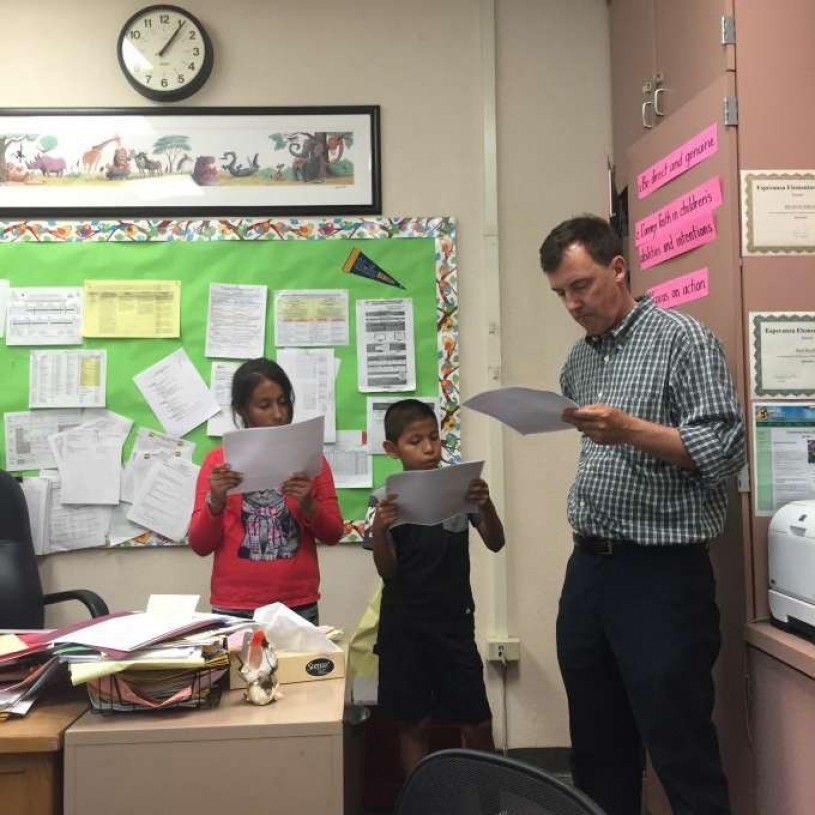 Kevin and Jennifer reciting their stories with assistance from their principal, Brad Rumble.