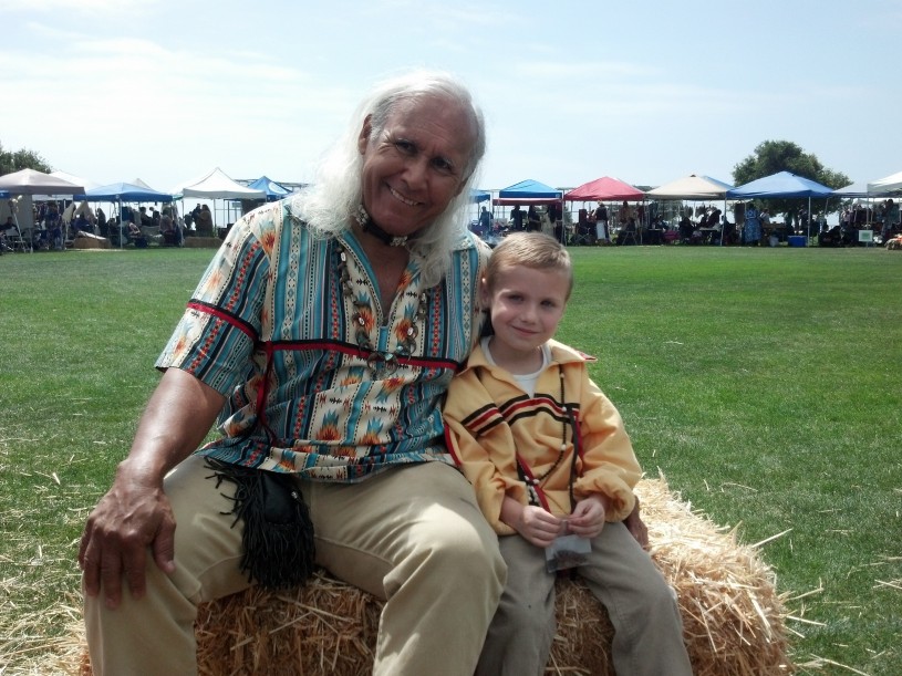 Alan sits next to his grandson Caden at the Chumash Powwow in Malibu California
