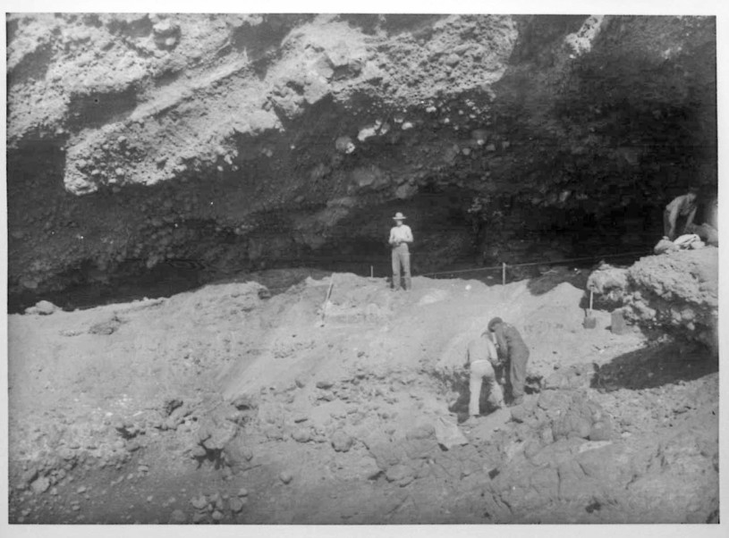 This picture shows the size of Big Dog Cave located on San Clemente Island, SCLI-119. One of the Marines stationed on the island that assisted with the excavations is shown standing in front of the cave.
