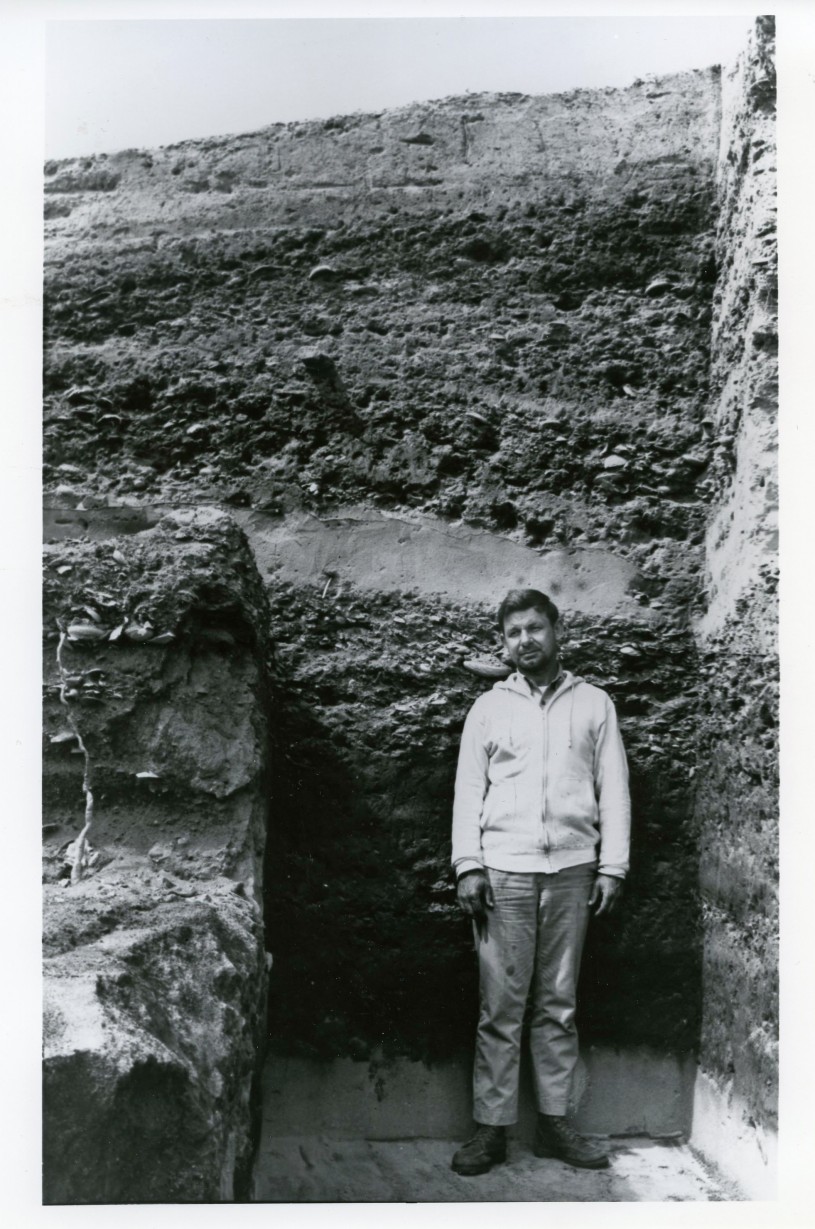 This image shows the depth of the excavations at Daisy Cave located on San Miguel Island, SMI-261. George Kritzman stands in front of the stratigraphy.