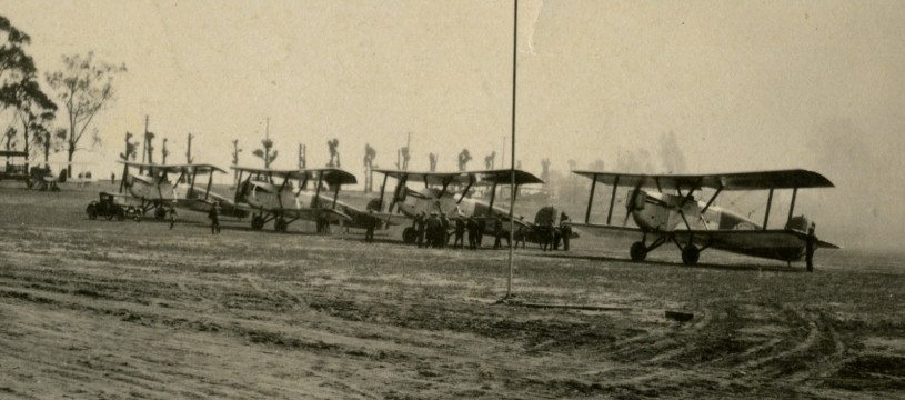 Four biplanes, the Douglas World Cruisers, lined up on a dirt runway, about to depart from Clover Field