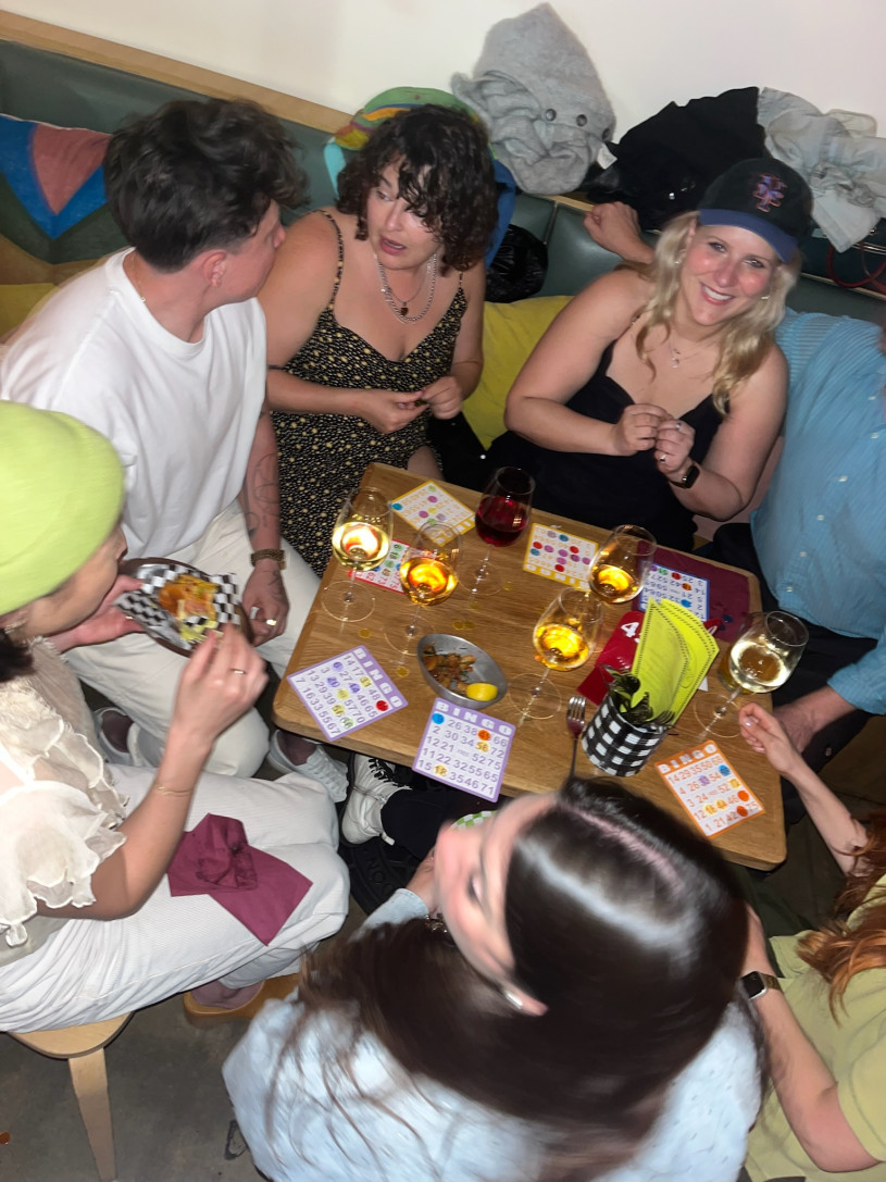 A group of people sitting at a table together playing a board game and laughing