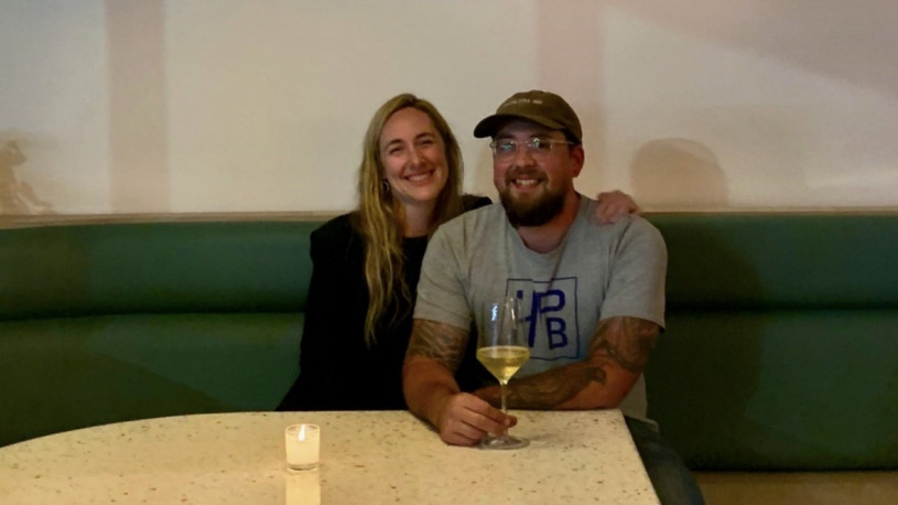 abrina and Spencer, the previous owners of the restaurant Izette, sitting together at a booth.
