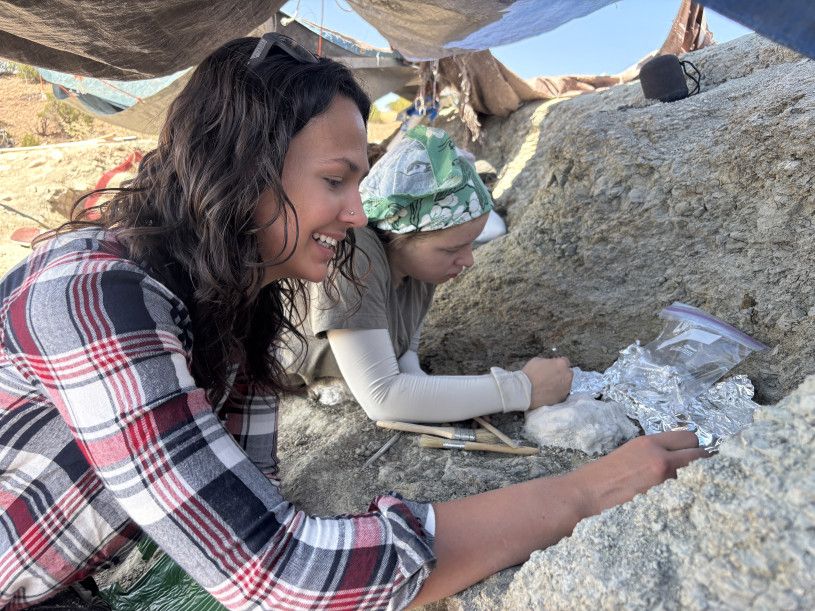Two young women dig into rock