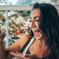 Aly Moore holding a spoonful of bugs ready to eat them