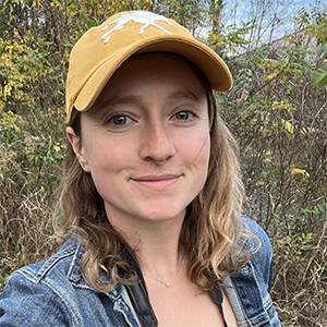 Jenna McCullough wearing a yellow hat with yellow flowers behind her