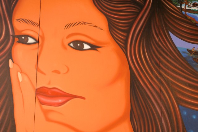 Closeup of a woman with swirling hair and with her hand on her face